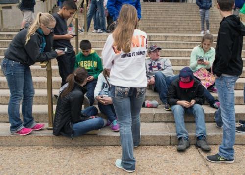 手机游戏低龄化趋势逐渐显现。一群青少年手机不离手。(图片来源：法新社