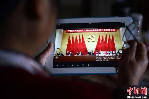 资料图：一位网友用平板电脑浏览有关中国共产党十八届三中全会的报道。<a target='_blank'  data-cke-saved-href='http://www.chinanews.com/' href='http://www.chinanews.com/'>中新社</a>发 张浪 摄