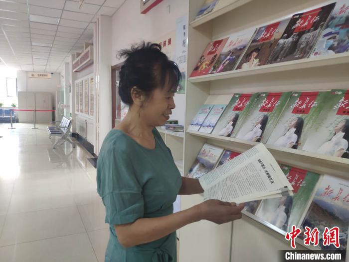 65岁的周云霞在社区看杂志打发时间。　谭伟旗 摄