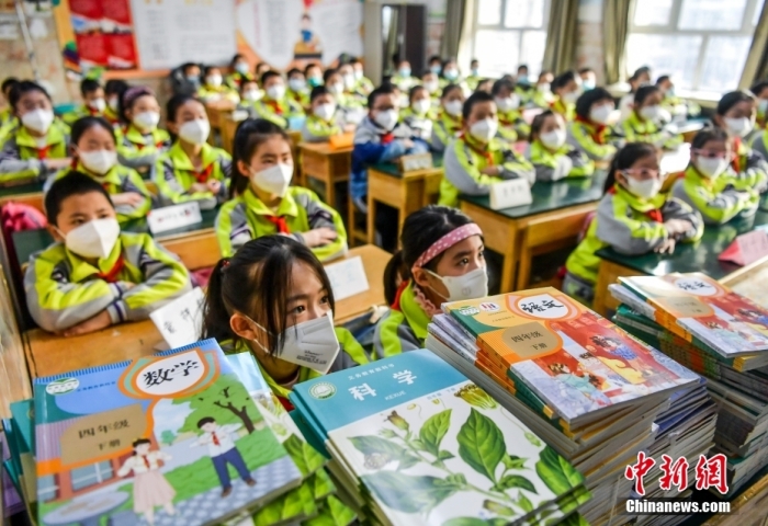 资料图：新疆乌鲁木齐市第四十二小学，学生们等待领取新课本。中新社记者 刘新 摄